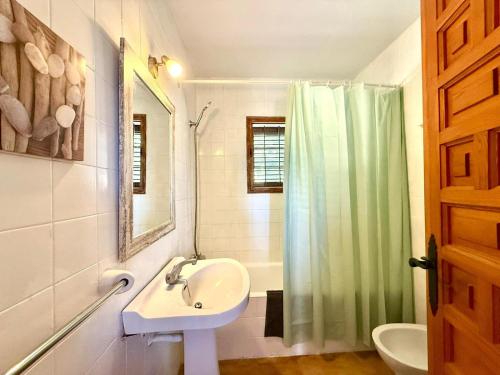 a bathroom with a sink and a shower curtain at Villa Sa Guaita in Sant Josep de sa Talaia