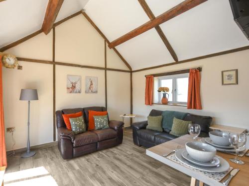 a living room with couches and a table at Cart House Barn - Uk49802 in Morville