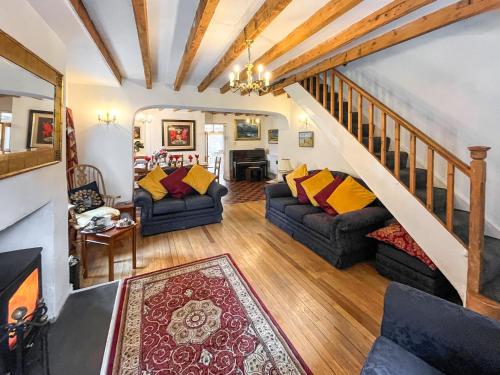 a living room with two couches and a staircase at Y Ddol in Llansannan
