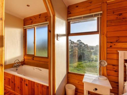 a bathroom with a tub and a window at Rivers End Farm Stanford - Cabins in Stanford