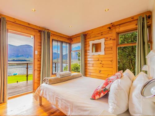 a bedroom with a bed and a large window at Rivers End Farm Stanford - Cabins in Stanford