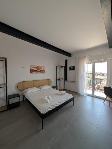 a bedroom with a large bed and a large window at The Essential - Reggia Di Caserta in Caserta