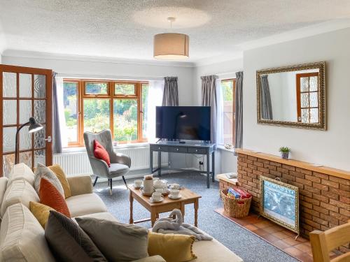 a living room with a couch and a tv at Dippers in Smallburgh