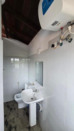 a bathroom with a white sink and a toilet at Melvila in Colombo