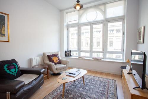 a living room with a couch and a table at The Art Flat Glasgow in Glasgow
