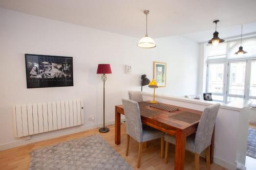 a dining room with a wooden table and chairs at The Art Flat Glasgow in Glasgow