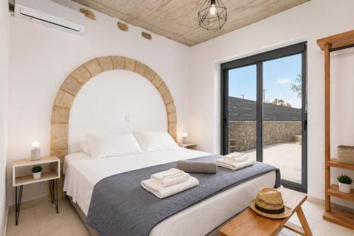a bedroom with a bed and a large window at La Casa Di Pietre 3 in Kiotari