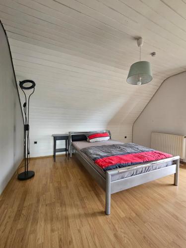 a bedroom with a bed and a lamp on a wooden floor at FeWo Zimmer Waldmohr in Waldmohr