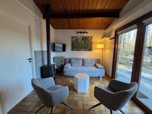 a living room with a couch and two chairs at Les Trois Feuilles in Petit Mesnil
