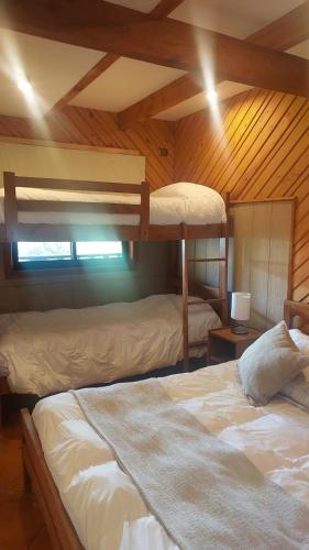 a bedroom with two bunk beds in a cabin at MI Lodge Las Trancas Hotel & Spa in Las Trancas