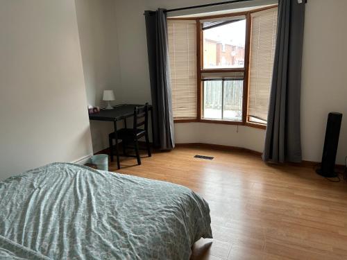 a bedroom with a bed and a desk and a window at HomeNet in Toronto