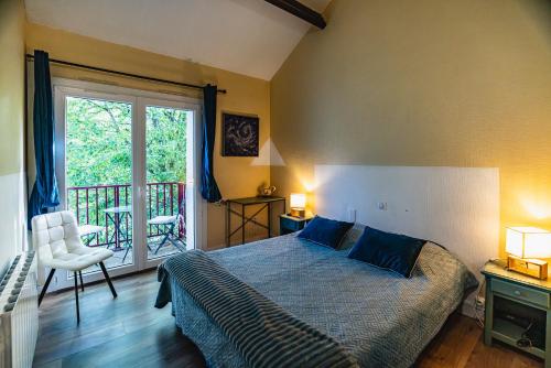 a bedroom with a bed and a balcony at Hotel de la Bonnheure in Bracieux