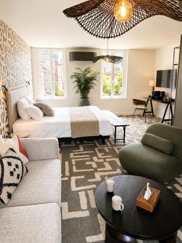 a hotel room with a bed and a living room at La villa 10 HÔTEL SPA in Étretat
