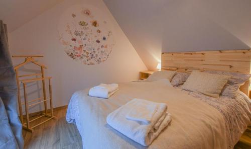a bedroom with a bed with towels on it at Le charme du moulin in Beauvoir-sur-Sarce