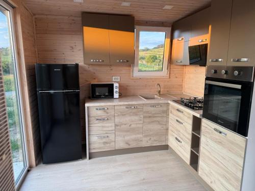 a kitchen with a black refrigerator and a microwave at Green Camp Resort in Hereclean