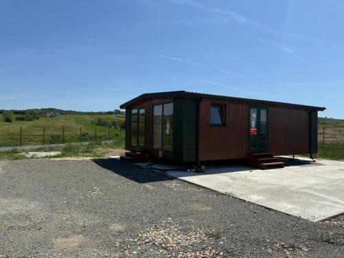 a green and brown tiny house in a parking lot at Green Camp Resort in Hereclean