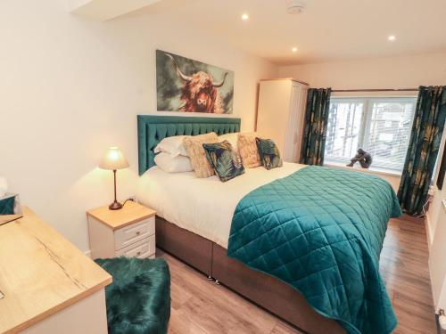 a bedroom with a bed with a green comforter at Hidden Gem in Windermere