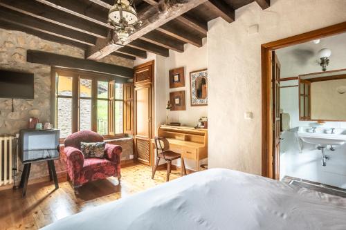 a bedroom with a bed and a desk and chair at Hotel Boutique Santuario Kunturi - Adults Only by Molino de Tresgrandas in Llanes