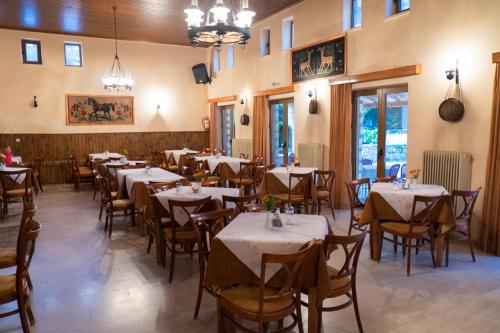 ein Restaurant mit Tischen und Stühlen in einem Zimmer in der Unterkunft Hotel Tzoumerka in Pramanta