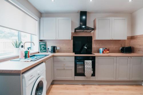 a kitchen with white cabinets and a dishwasher at The Livingston Nest in Livingston
