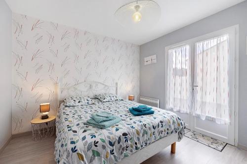 a bedroom with a bed with a floral bedspread at Chambre D'hôtes Le Retour De Plage in Olonne-sur-Mer