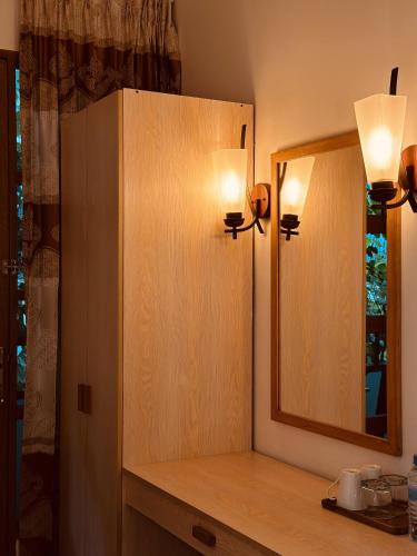 a bathroom with a mirror and a wooden cabinet at Odi Kamadhoo in Kamadhoo