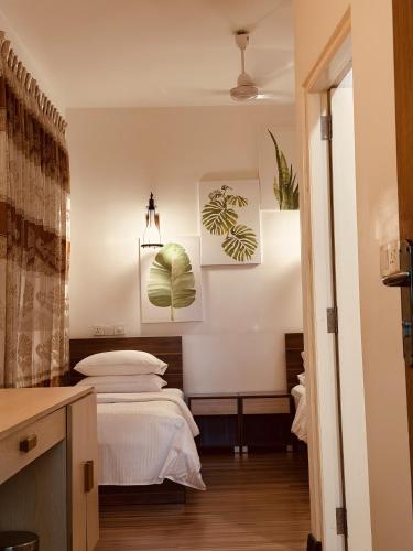 a bedroom with a bed and two paintings on the wall at Odi Kamadhoo in Kamadhoo