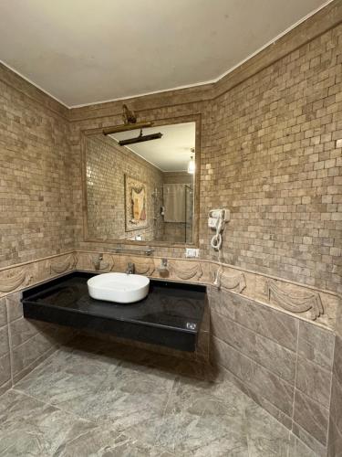 a bathroom with a sink and a mirror at Dyafa Pyramids Hotel in Cairo