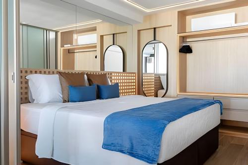 a bedroom with a large white bed with blue pillows at Azure Loft: Sea & Luxury in Rio de Janeiro