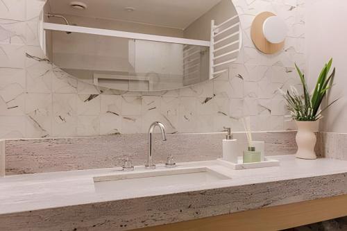 a bathroom with a sink and a mirror at Azure Loft: Sea & Luxury in Rio de Janeiro