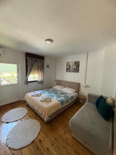 a bedroom with a bed and a couch at WIN apartment in Plužine