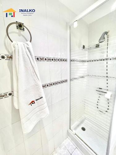 a bathroom with a shower and a white towel at Cala Montero - Inalko in Alcossebre