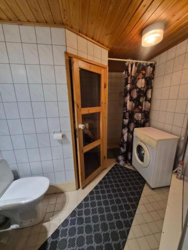 a small bathroom with a toilet and a window at MiniMani House with Sauna in Sorsakoski