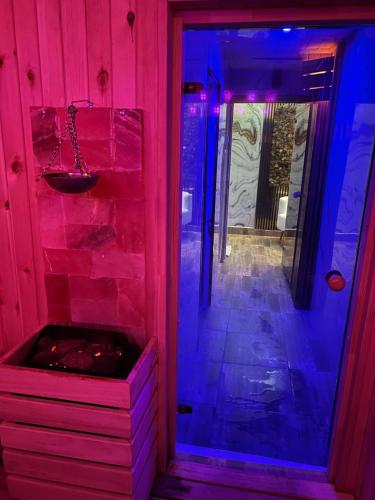 a pink and blue lighted room with a jacuzzi at Комплекс Тополица -The beautiful view in Aytos