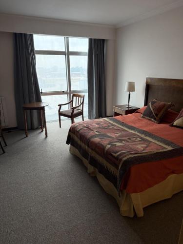 a hotel room with a bed and a large window at Palmar Hotel Casino in Concordia