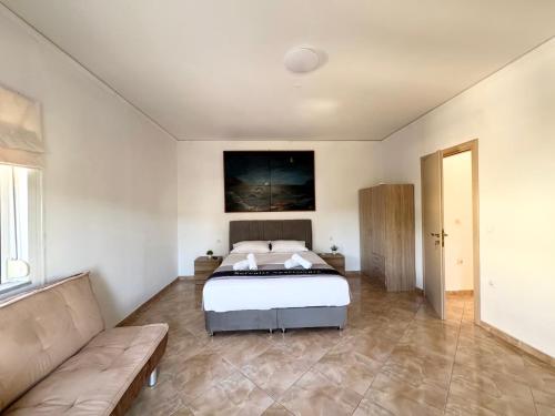 ein großes Schlafzimmer mit Bett und Sofa in der Unterkunft Serenity house in Souda