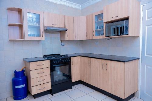 a kitchen with wooden cabinets and a stove top oven at Mainway home in Harare