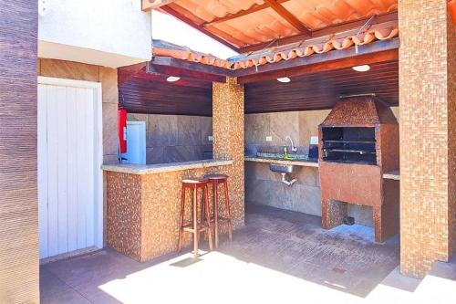 an outdoor kitchen with a stove and a counter with stools at Happy Hotel Ancoradouro in Porto Seguro