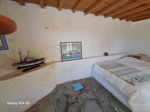 a bedroom with a bed and a boat on the wall at Charmante maison cycladique traditionnelle in Faros