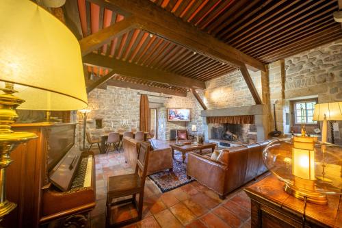 a living room with leather furniture and a stone wall at Château de Tournou in Castelreng