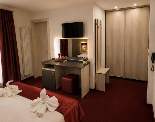 a hotel room with two beds and a desk and a mirror at Hotel Solymar in Mangalia