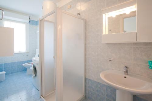 y baño con lavabo, ducha y aseo. en Colombo Apart-Hotel 4 Stars Luxury with swimming Pools on the roof where you can see the Sea and with covered parking space, en Caorle