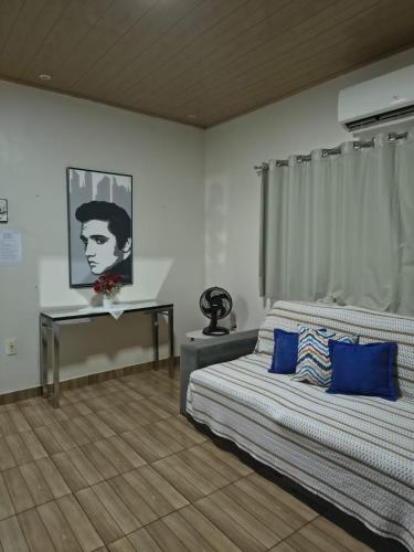 a bedroom with a bed with blue pillows and a desk at Casa Privativa com Piscina, Churrasqueira, Wi-Fi e Ar-Condicionado em Manaus in Manaus
