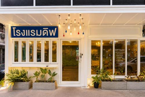 a store front with a sign that reads isuzuatown at Diff Hostel in Bangkok