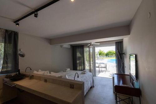 a bedroom with a bed and a view of a pool at Gyra Villas - Seaview Villa Fivos with private pool in Lefkada