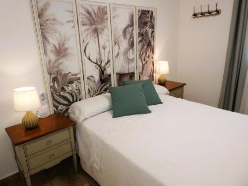 a bedroom with a white bed with two night stands and two lamps at Casa Rural Isabel y Luis in Chiloeches
