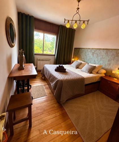 ein Schlafzimmer mit einem Bett, einem Tisch und einem Fenster in der Unterkunft Lar Do Lago - Rooms in Negreira