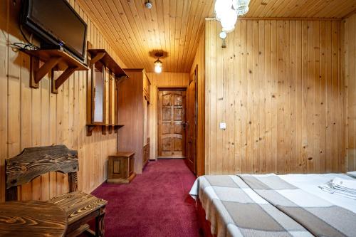 a bedroom with wooden walls and a bed and a tv at Марина in Bukovel