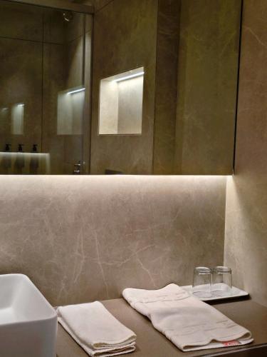 a bathroom with a sink and a mirror and towels at Krishna Palace Hotel , Ulhasnagar in Ulhāsnagar