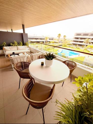 a balcony with a table and chairs and a pool at CasaBlanka Premium Apartment with Pool & Wellness in Torrevieja